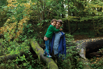 Father and son standing on a tree branch