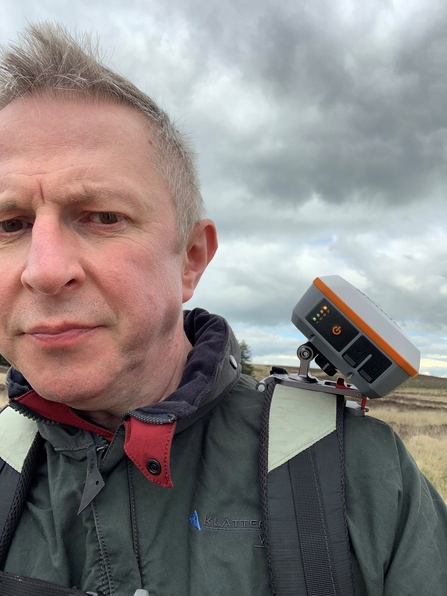 Geode GIS receiver on the shoulder strap of a rucksack