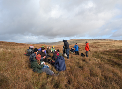 A group of participants on the Peatland Pathways course taking a lunchbreak on a peat bog